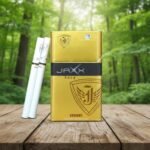 ซองบุหรี่ Jaxx Gold สีทองและมวนบุหรี่ วางบนโต๊ะไม้ท่ามกลางบรรยากาศสวนสีเขียว