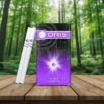 ซองบุหรี่ Oris Intense Purple Fizz ดีไซน์สีม่วงล้ำสมัย วางบนโต๊ะไม้ในสวนป่า