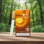 ซองบุหรี่ ESSE Ice Cafe สีน้ำตาลทองลายเกลียว พร้อมมวนบุหรี่ วางบนโต๊ะไม้ฉากหลังเป็นป่าธรรมชาติ