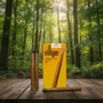 กล่องซิการ์ Villiger Premium No.6 Honey Tip สีเหลือง พร้อมมวนซิการ์ใบยาสด วางบนโต๊ะไม้ฉากหลังป่าธรรมชาติ