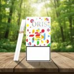 ซองบุหรี่ Oris Chao Society White ลวดลายกราฟิกสีสันสดใสบนพื้นขาว พร้อมมวนบุหรี่สลิม วางบนโต๊ะไม้กลางป่า