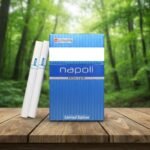 บุหรี่ Napoli Blue Limited Edition วางบนโต๊ะไม้ ท่ามกลางบรรยากาศป่าธรรมชาติสีเขียว