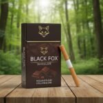 บุหรี่ Black Fox Chocolate กล่องสีน้ำตาลลายช็อกโกแลตและรูปสุนัขจิ้งจอก วางบนโต๊ะไม้