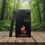 ซองบุหรี่ XSO Chocolate สีดำหรูหราพร้อมมวนบุหรี่สีดำวางบนโต๊ะไม้ในบรรยากาศป่าไม้