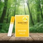 ซองบุหรี่ Golden Flower สีเหลืองทองลายดอกกุหลาบ วางบนโต๊ะไม้ท่ามกลางธรรมชาติ