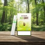 ซองบุหรี่ Raison Ice Cafe สีขาวเขียวลายแมววางบนโต๊ะไม้ฉากหลังป่าธรรมชาติ