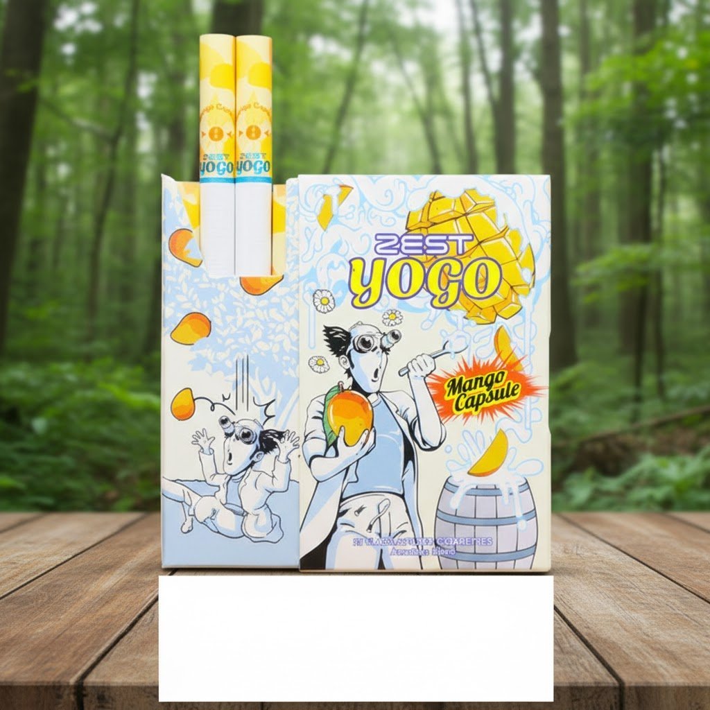 บุหรี่ Zest Yogo Mango Capsule ซองดีไซน์อาร์ตสีสันสดใส กลิ่นโยเกิร์ตมะม่วง วางบนพื้นไม้ในบรรยากาศธรรมชาติ