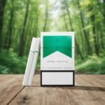 บุหรี่ Marlboro White Menthol ซองสีขาวคาดแถบสีเขียวเมทัลลิก วางบนโต๊ะไม้ฉากหลังป่าไม้ธรรมชาติ