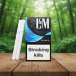 บุหรี่ L&M Storm 7.1 ซองสีดำลายคลื่นสีฟ้าสดใส พร้อมมวนบุหรี่สีขาววางบนโต๊ะไม้ฉากหลังป่า