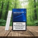 ซองบุหรี่ Mevius Original Blue สีน้ำเงินเข้มดีไซน์พรีเมียม วางคู่กับมวนบุหรี่บนโต๊ะไม้กลางป่า