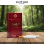 ซองบุหรี่ Davidoff Classic สีแดงเข้มหรูหรา วางบนโต๊ะไม้ฉากหลังเป็นป่าธรรมชาติ พร้อมมวนขนาด Magnum ก้นกรองสีส้ม