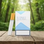 บุหรี่ Napoli Blue Special ซองสีขาวแถบฟ้าสไตล์มินิมอล วางบนโต๊ะไม้ฉากหลังป่าสีเขียว