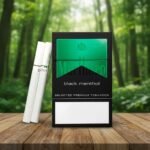 ซองบุหรี่ Marlboro Black Menthol สีดำตัดเขียว วางบนโต๊ะไม้กลางป่า แสดงมวนบุหรี่สีขาว ดีไซน์เรียบหรูและพรีเมียม