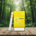 บุหรี่ Oris Pulse Mango Mint มวนซุปเปอร์สลิม 1 เม็ดบีบ รสมะม่วงมิ้นท์ วางบนโต๊ะไม้ฉากหลังป่า