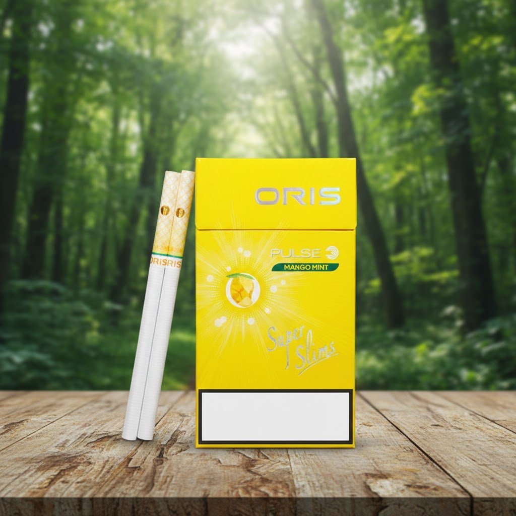 บุหรี่ Oris Pulse Mango Mint มวนซุปเปอร์สลิม 1 เม็ดบีบ รสมะม่วงมิ้นท์ วางบนโต๊ะไม้ฉากหลังป่า
