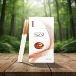 บุหรี่ Mond Chocolate ซองสีขาวลายกราฟิกเกลียวคลื่นสีน้ำตาลช็อกโกแลต วางคู่กับมวนบุหรี่ขนาดซุปเปอร์สลิมบนโต๊ะไม้ฉากหลังป่าธรรมชาติ