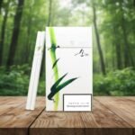 ซองบุหรี่ ESSE Bamboo 1mg ลายไม้ไผ่สีเขียว วางบนโต๊ะไม้ท่ามกลางบรรยากาศสวนป่าธรรมชาติ