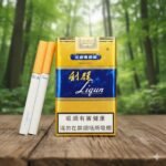 บุหรี่ Liqun Gold ซองสีทองแถบน้ำเงิน มวนก้นกรองสีส้มลายจุดทอง วางบนโต๊ะไม้ฉากหลังสวนสีเขียว