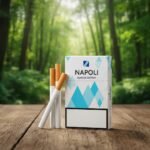 ซองบุหรี่ Napoli Blue Special สีขาวลายเรขาคณิตสีฟ้า วางบนพื้นผิวโต๊ะไม้ท่ามกลางฉากหลังธรรมชาติ