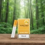 กล่องบุหรี่ Golden Flower สีเหลืองทองลายดอกกุหลาบ วางบนโต๊ะไม้ในสวนป่าสีเขียว